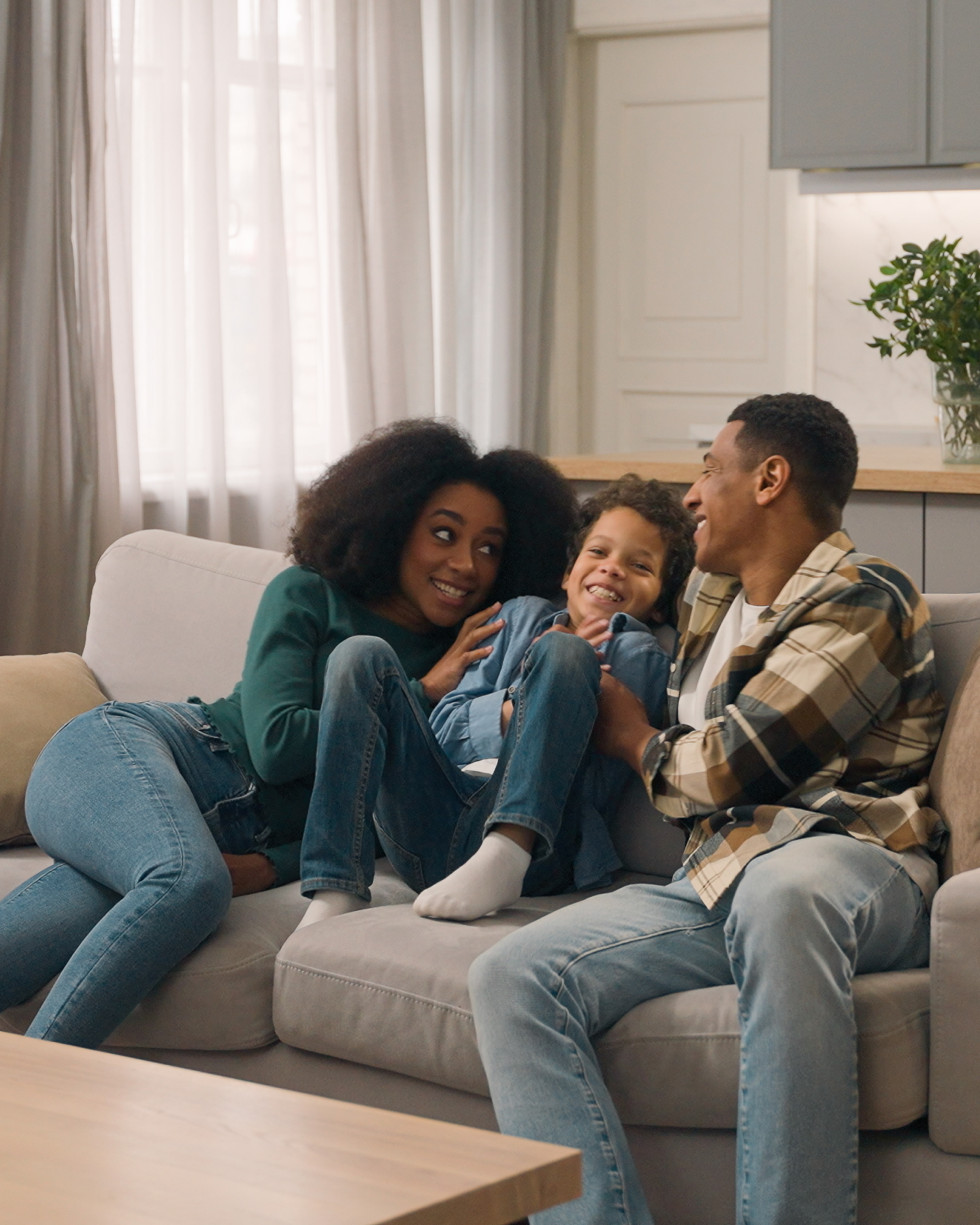 A family is sitting on a couch in a living room.