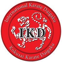 The logo for the international karate daigaku is a red circle with a tiger on it.