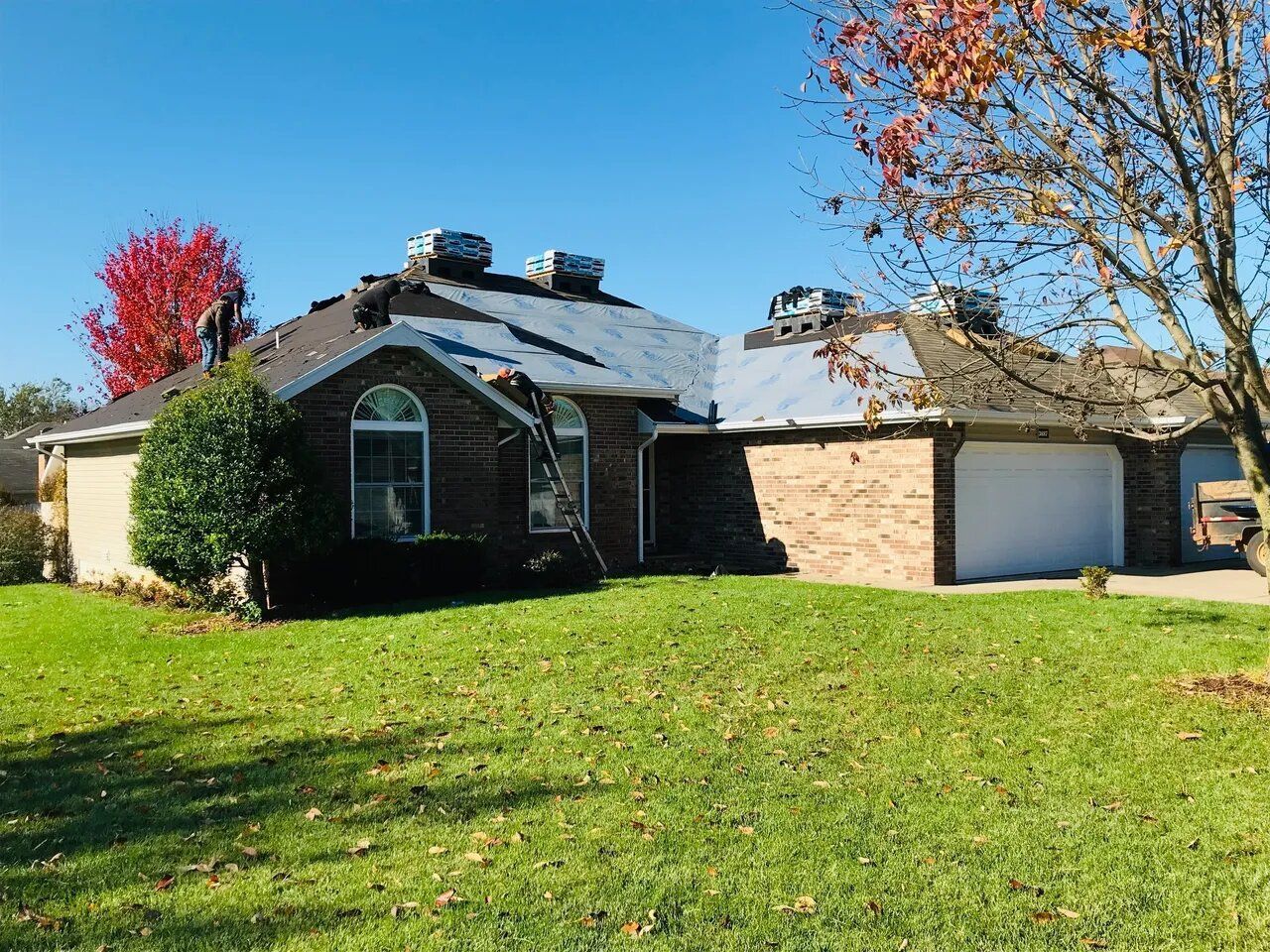 A brick house with a roof that is being installed.