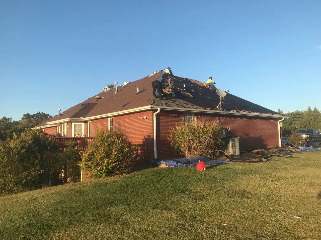Two men are working on the roof of a house.