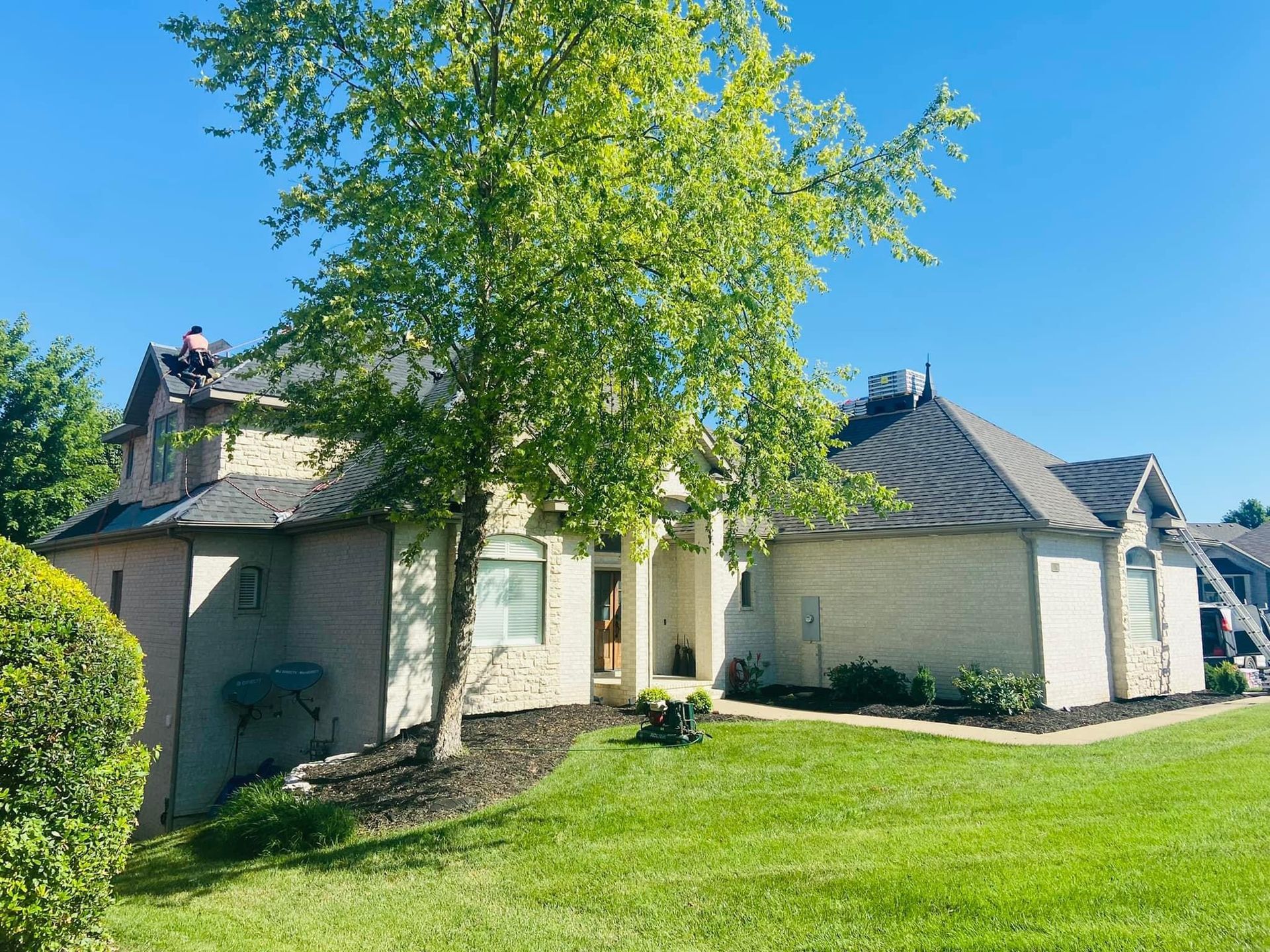 A large white house with a tree in front of it.