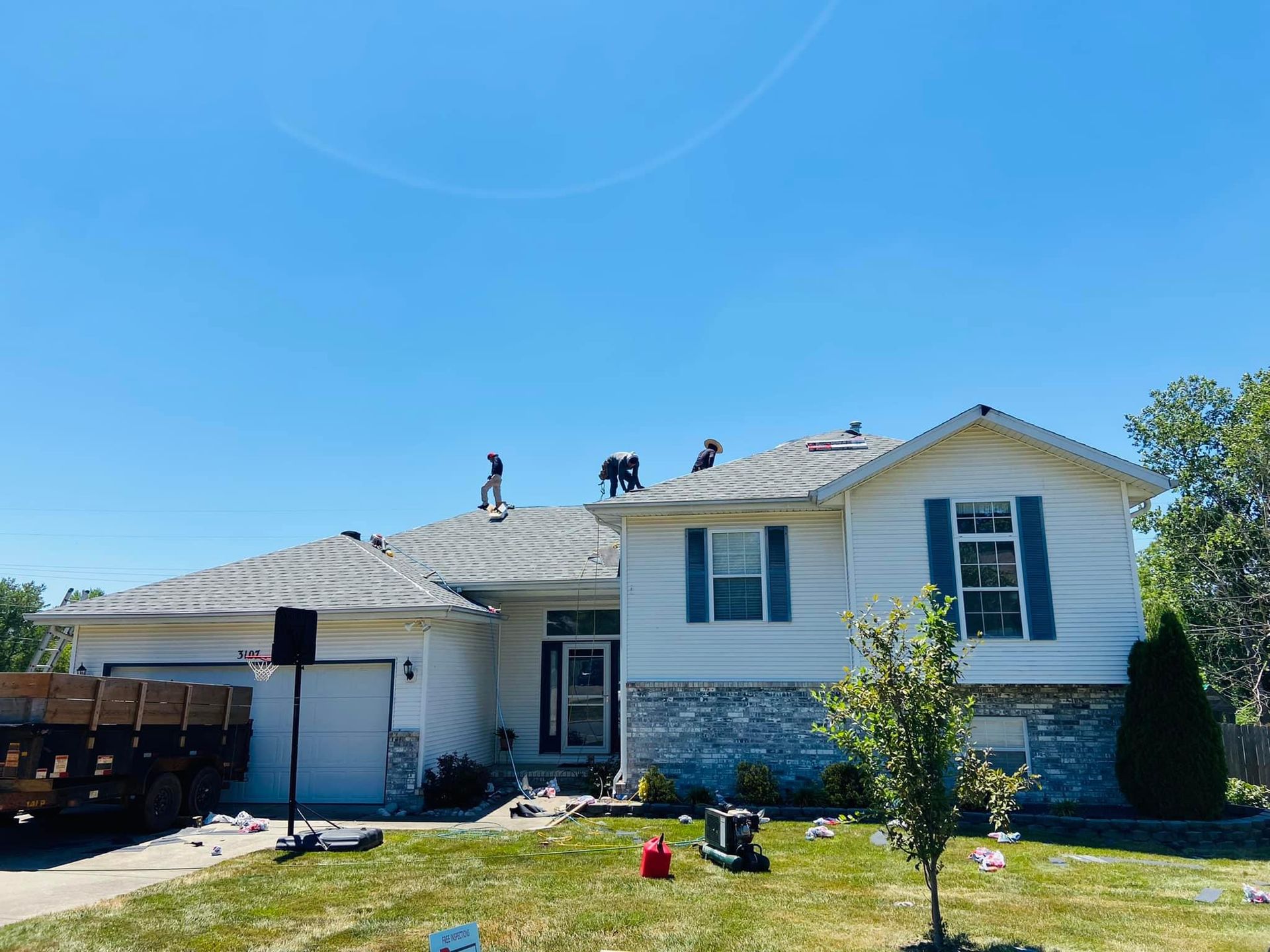 A white house with a roof that is being installed.