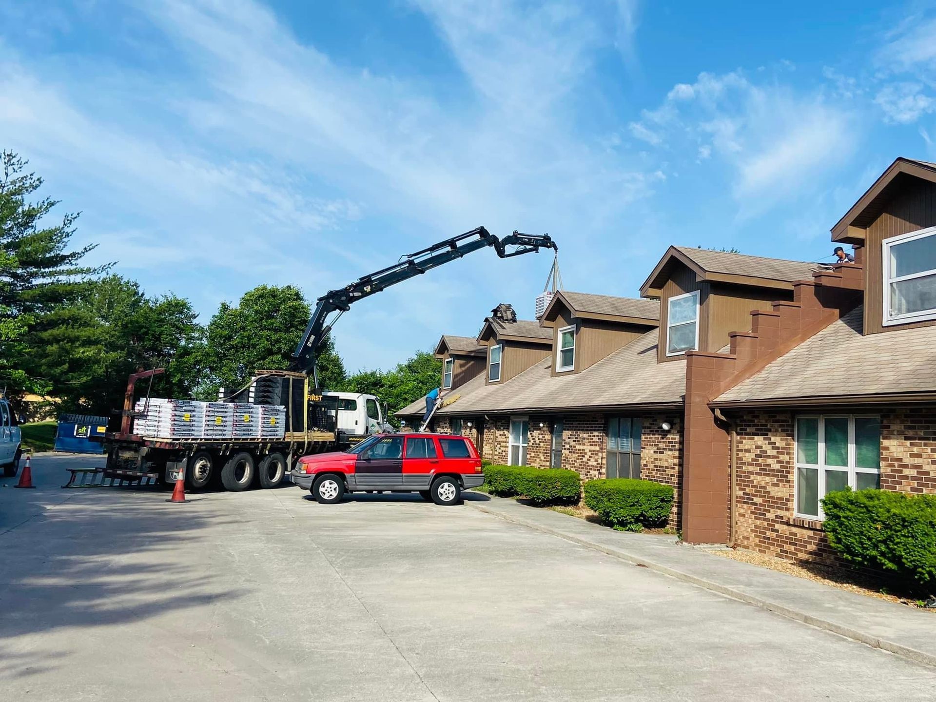 A truck with a crane attached to it is parked in front of a building.