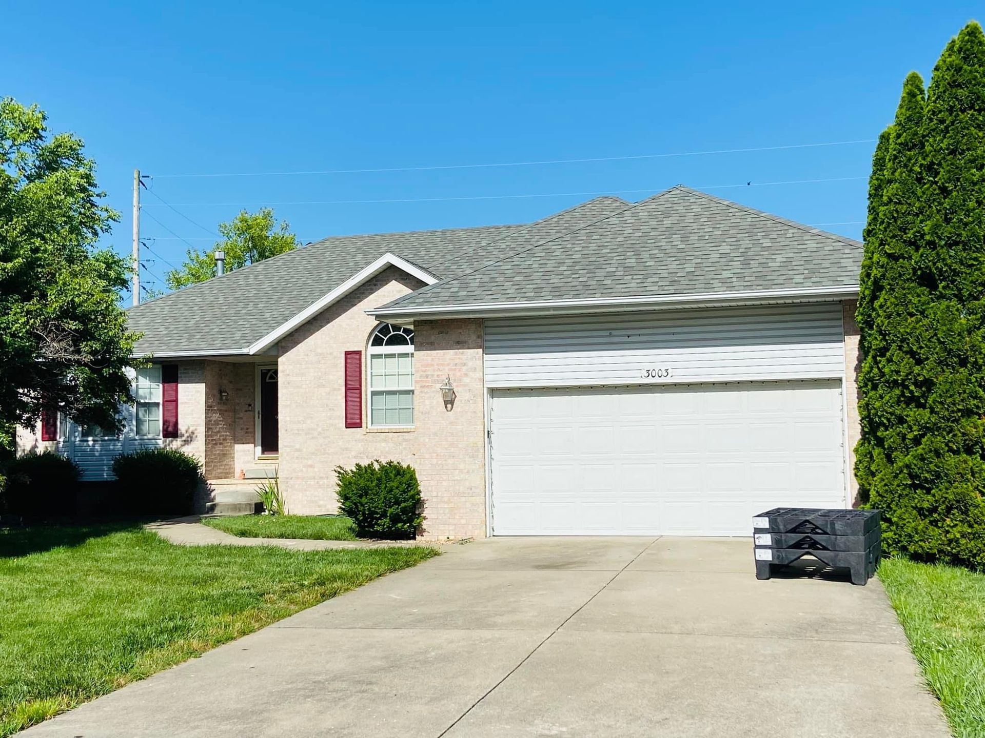 A house with a white garage door and a truck parked in front of it.