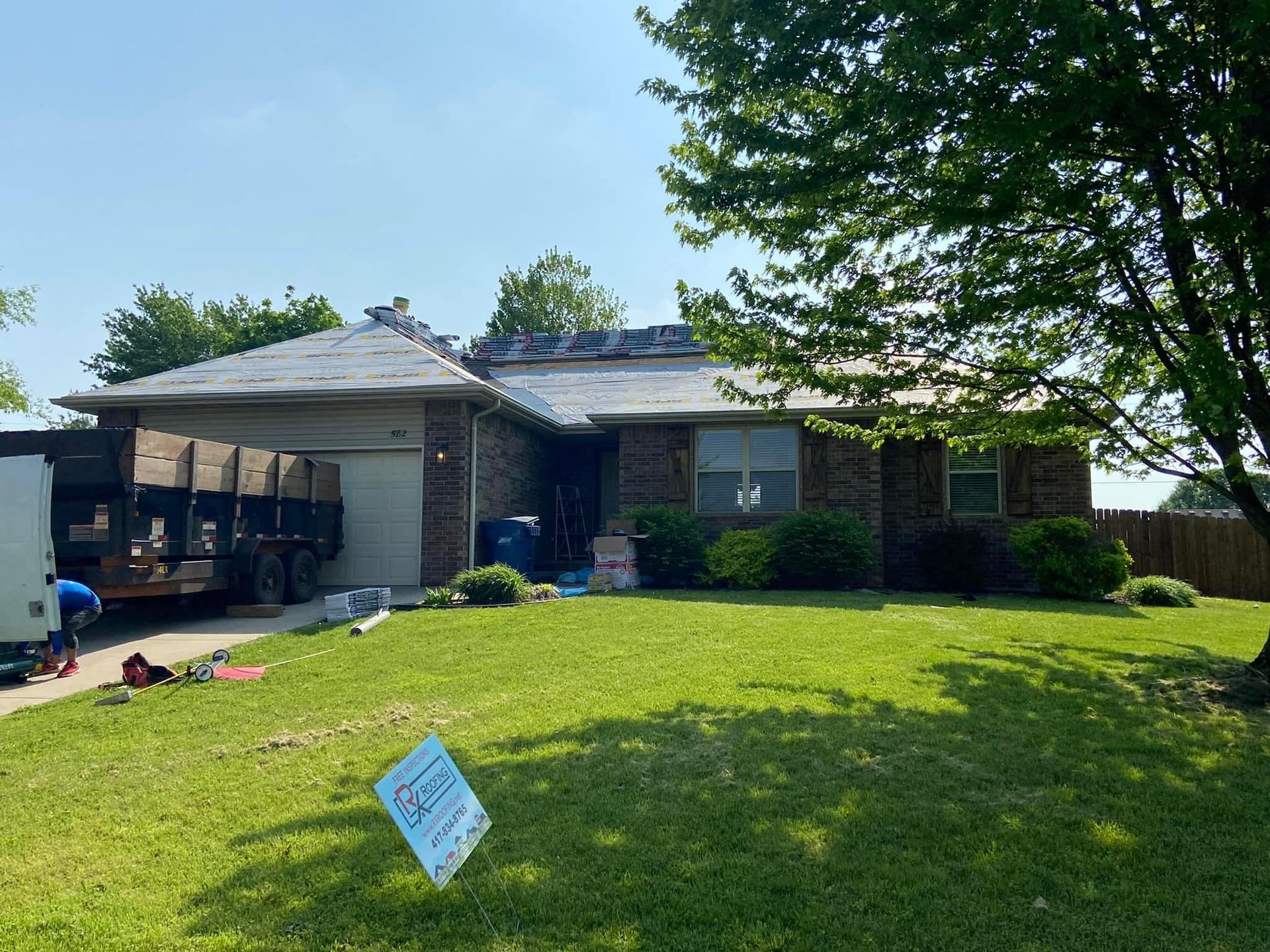 A house with a truck parked in front of it and a sign in front of it.