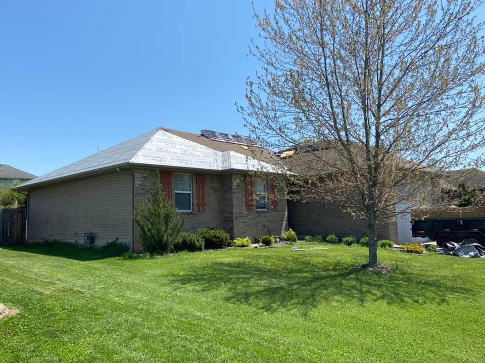 A brick house with a tree in front of it.