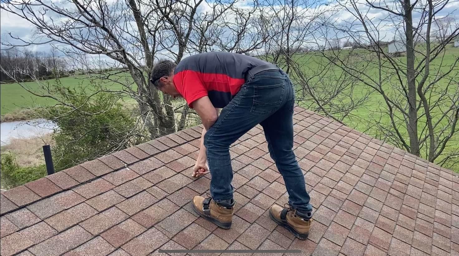 A man is standing on top of a brick roof.