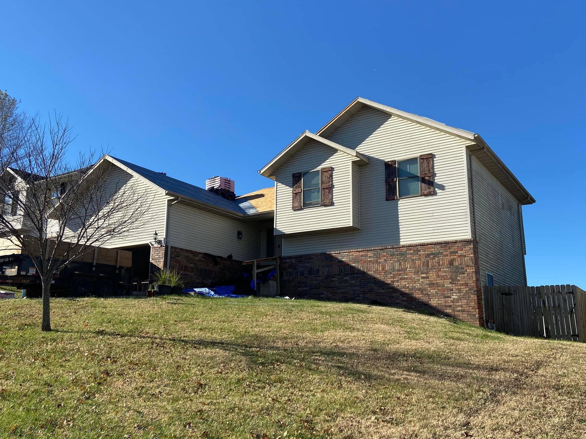 A large house is sitting on top of a grassy hill.