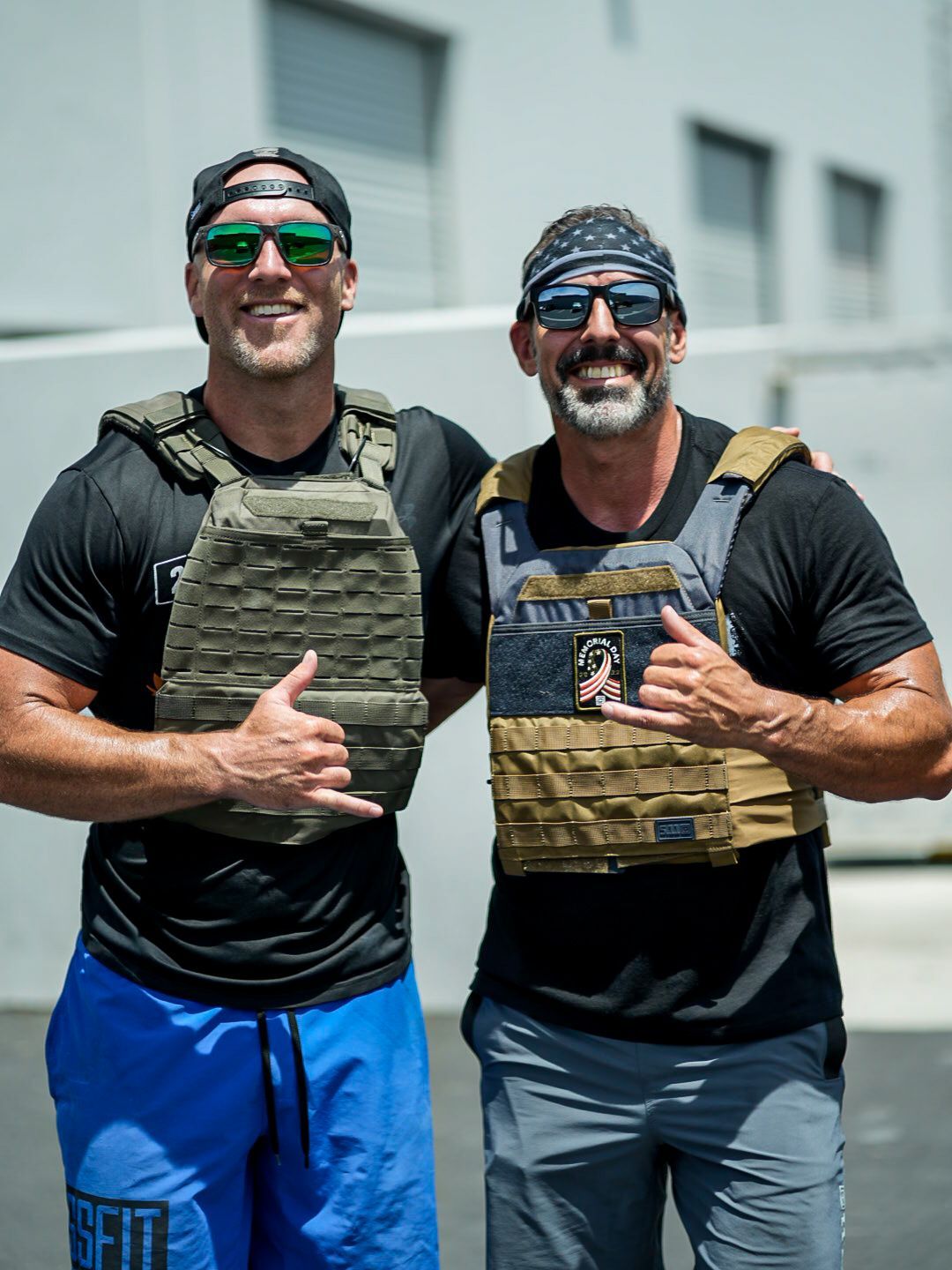 Two men wearing weighted vests, giving 