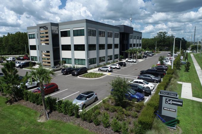 A large building with a lot of cars parked in front of it.