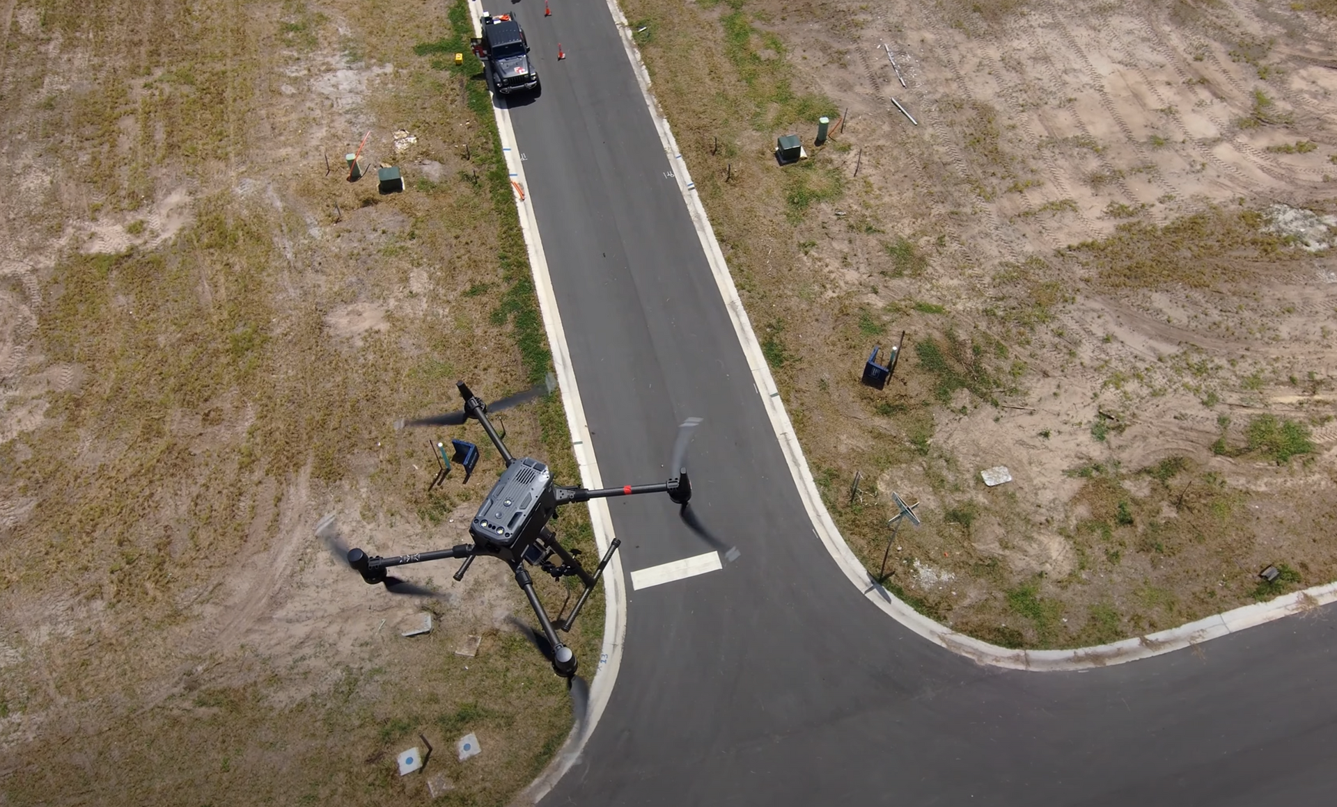 An aerial view of a drone flying over a road.