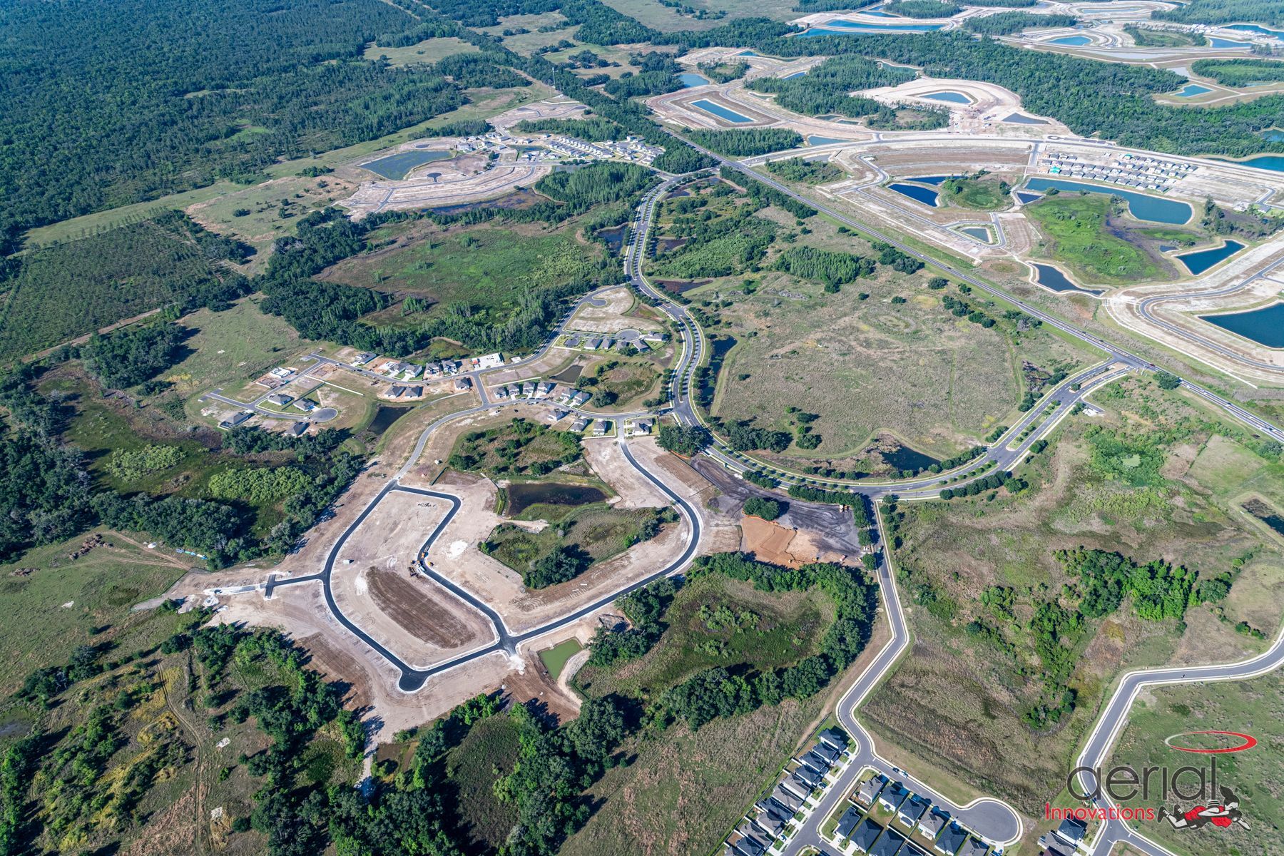 An aerial view of a construction site with a lot of trees and roads.