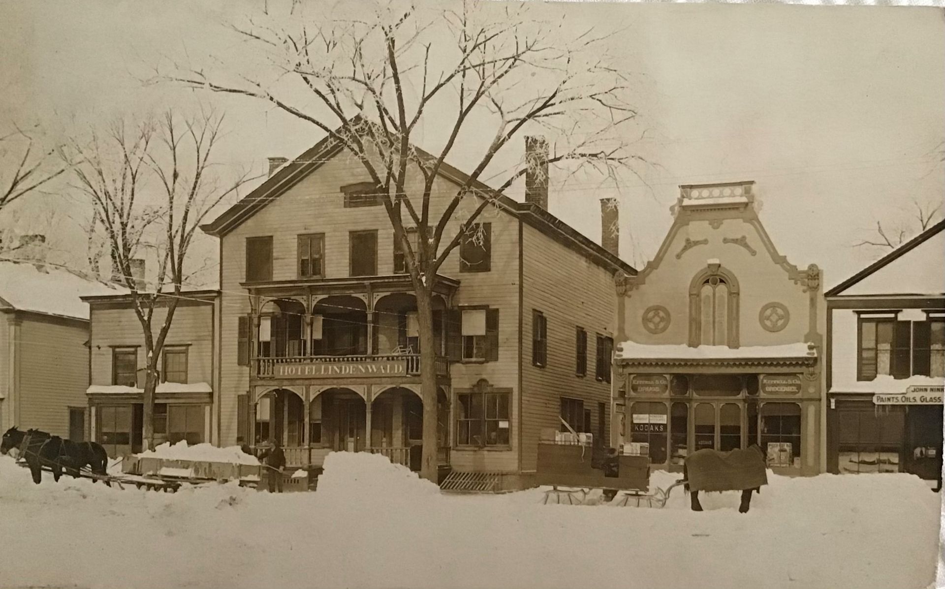 A winter scene showing the hotel with a sign reading,