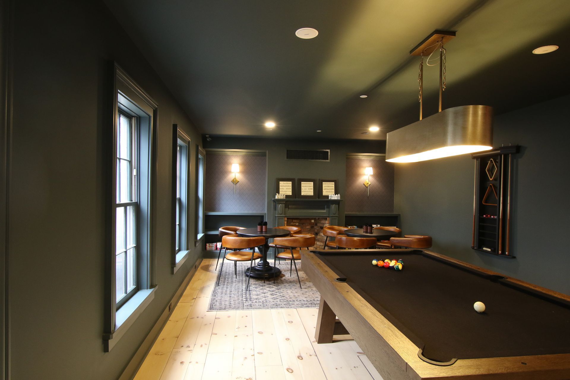 a game room with billiards table and two card tables