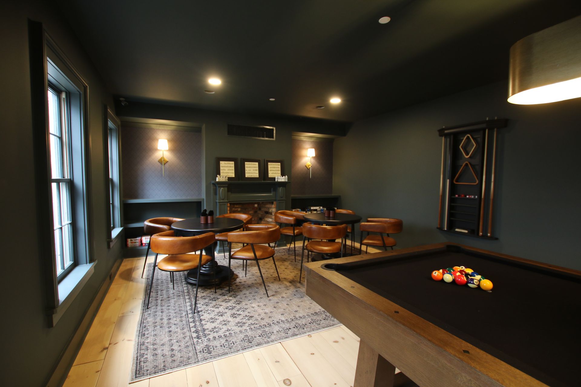a game room with two card tables and a billiards table