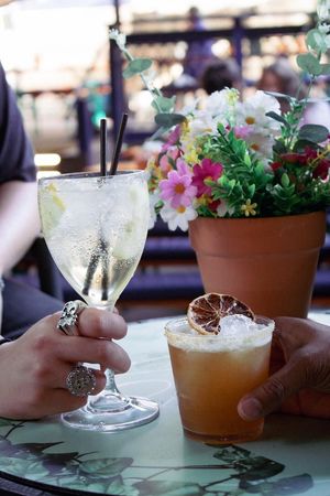 Two drinks are sitting on a bar next to each other.