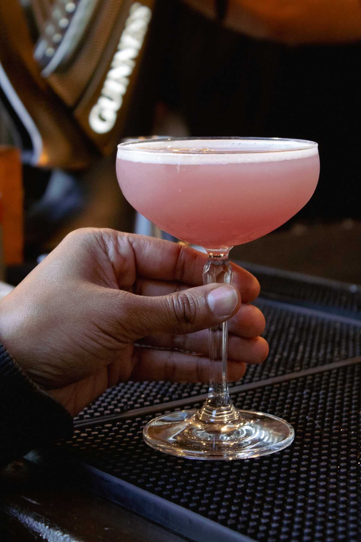 Two drinks are sitting on a bar next to each other.