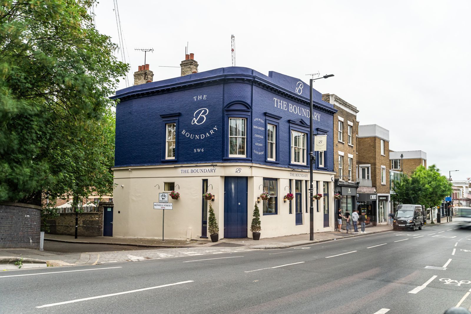 A blue and white building is on the corner of a street.