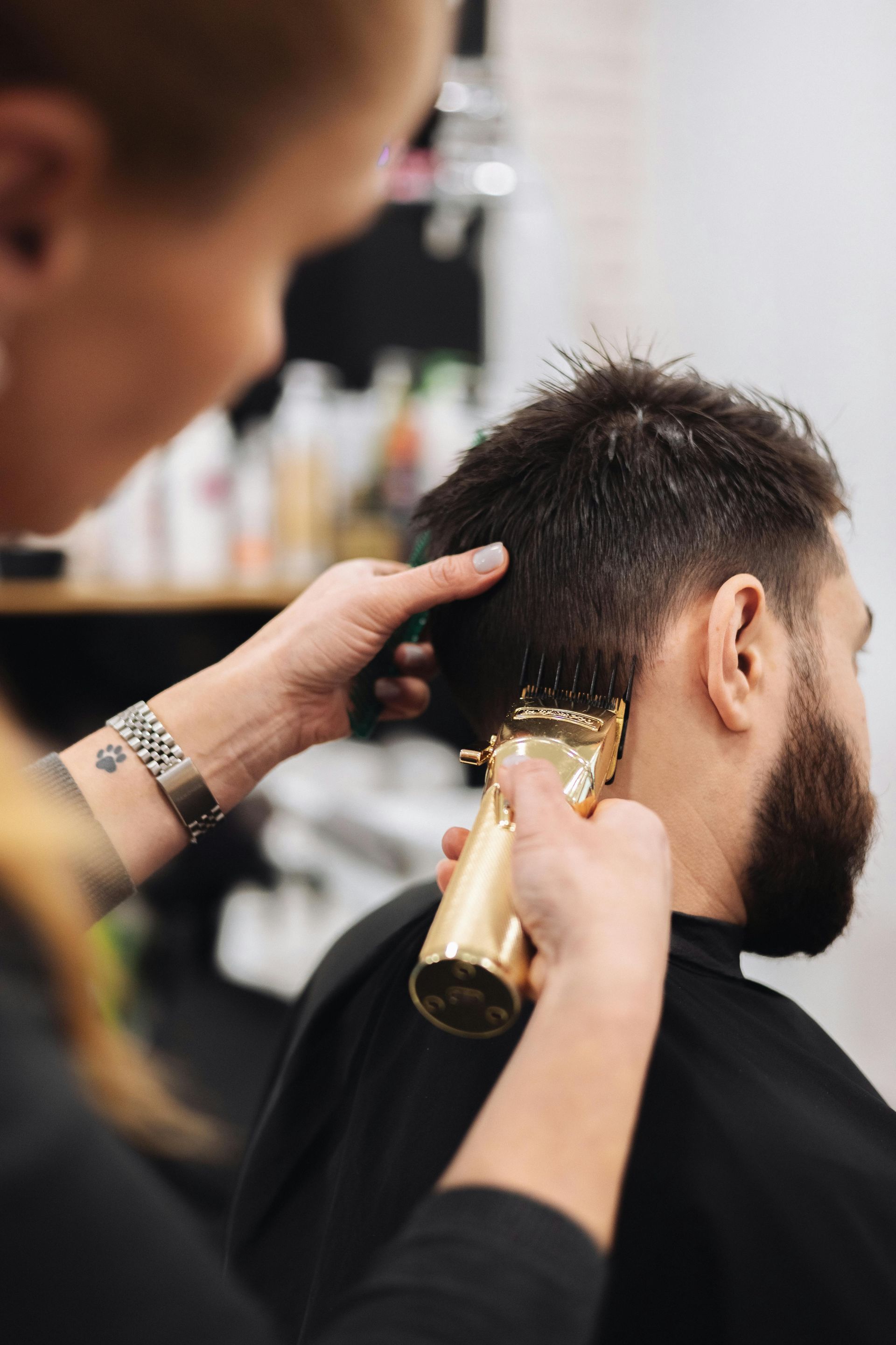 A man is getting his hair cut by a barber in a barber shop.