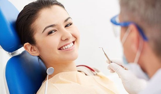 Smiling patient with the dentist above to diagnose