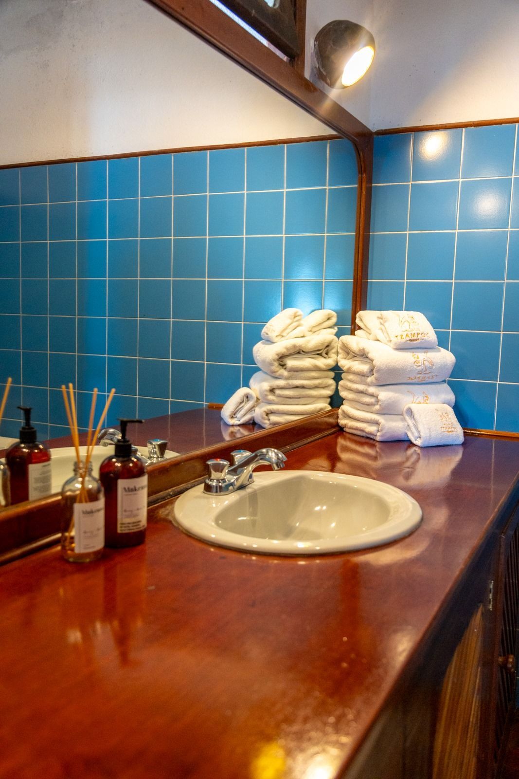 Un baño con lavabo, espejo y toallas en el mostrador.