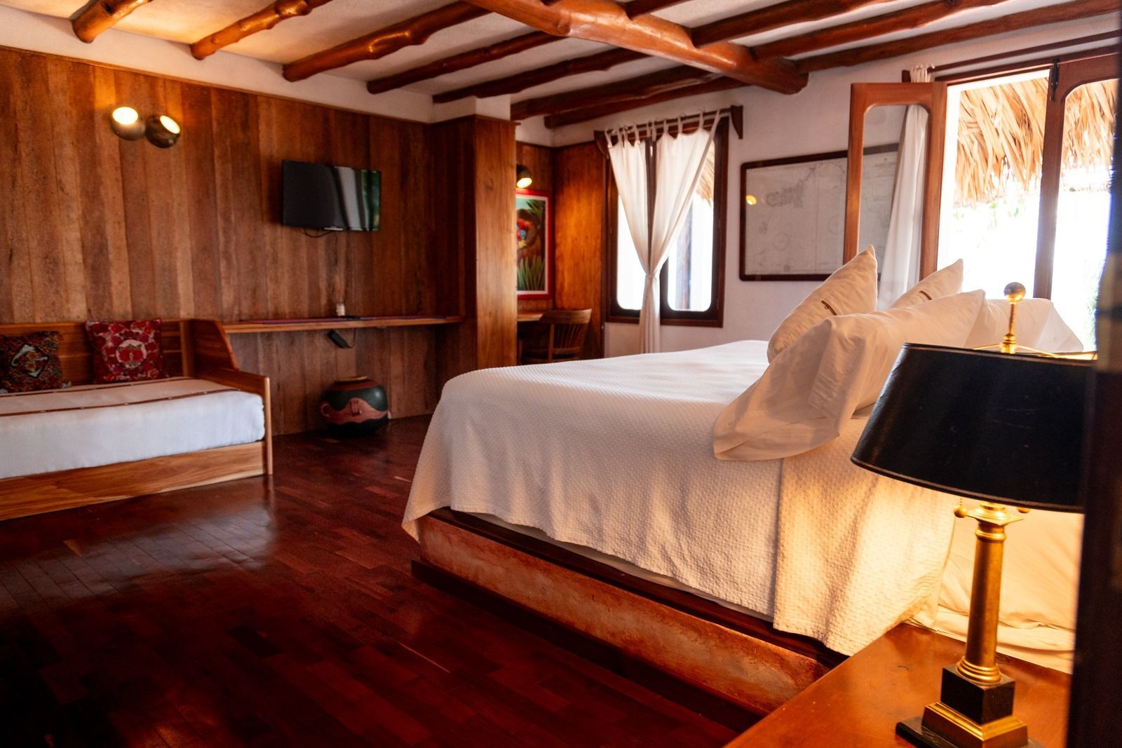 Un dormitorio con una cama king size y una lámpara. Tzampoc Resort