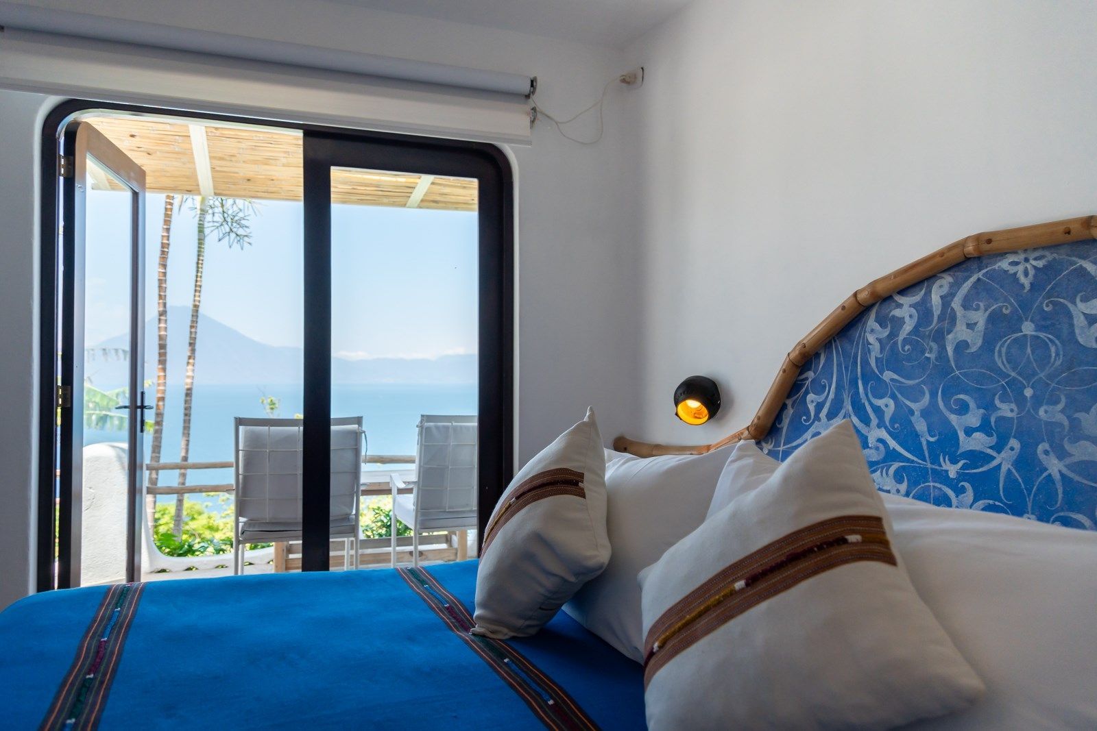 Una habitación de hotel con una cama y vista al lago. Tzampoc Resort