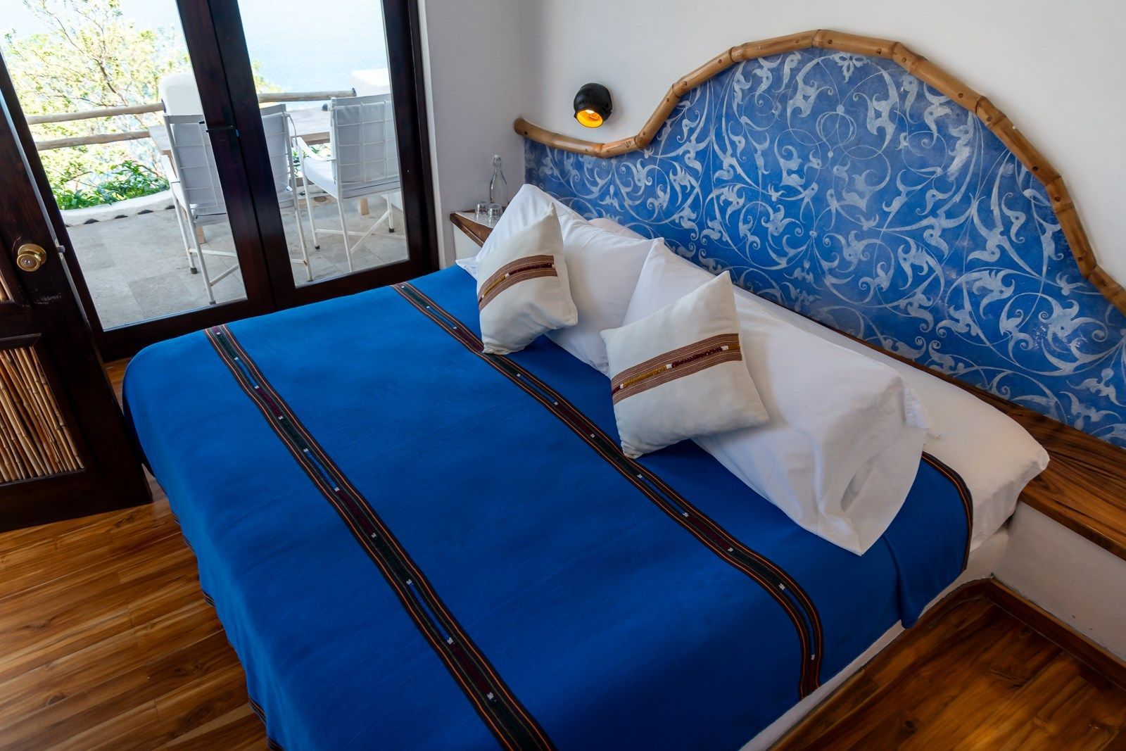 Una habitación de hotel con una cama tamaño king y una manta azul. Tzampoc Resort