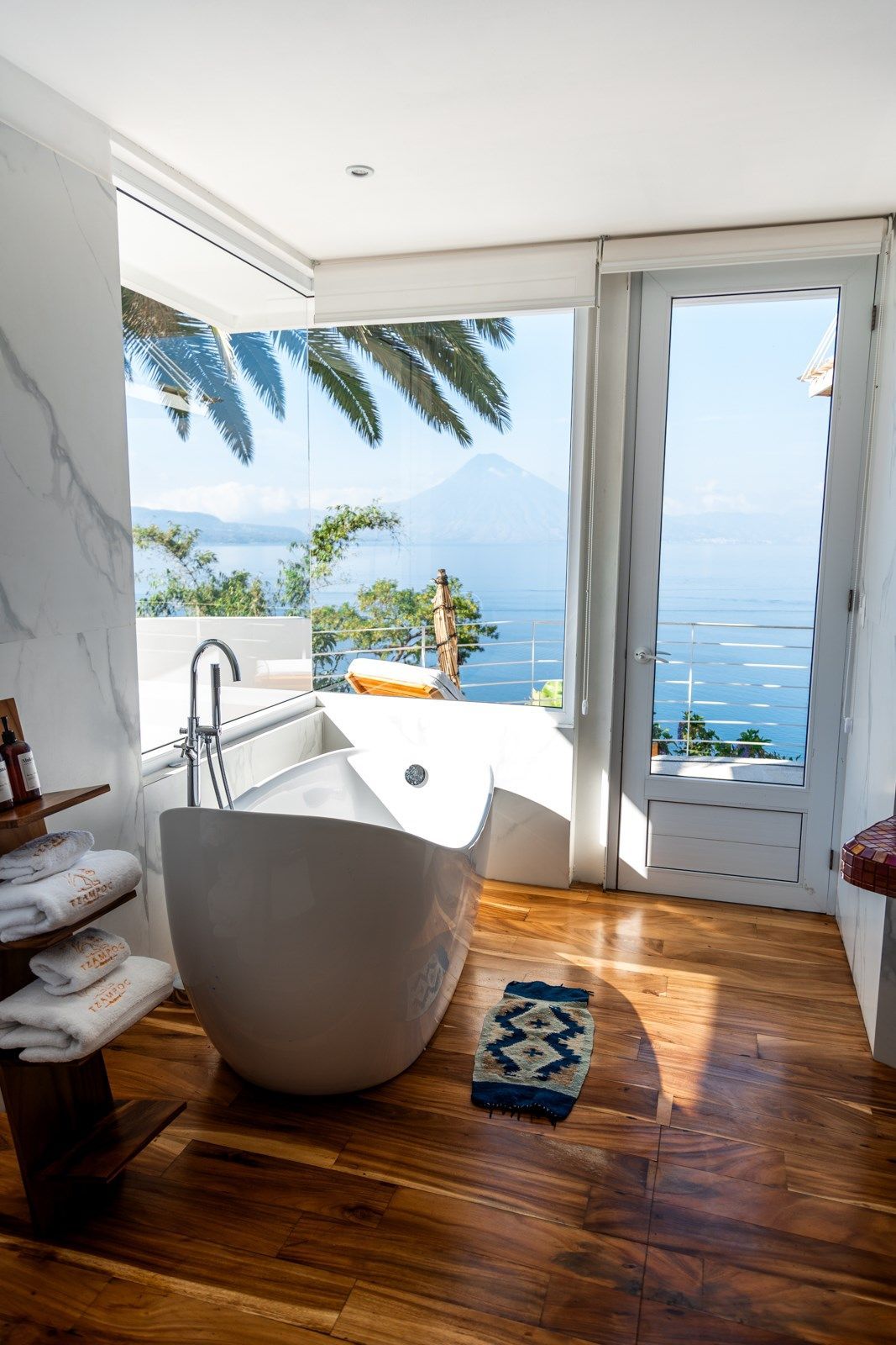 Un baño con bañera y una ventana con vista al mar.