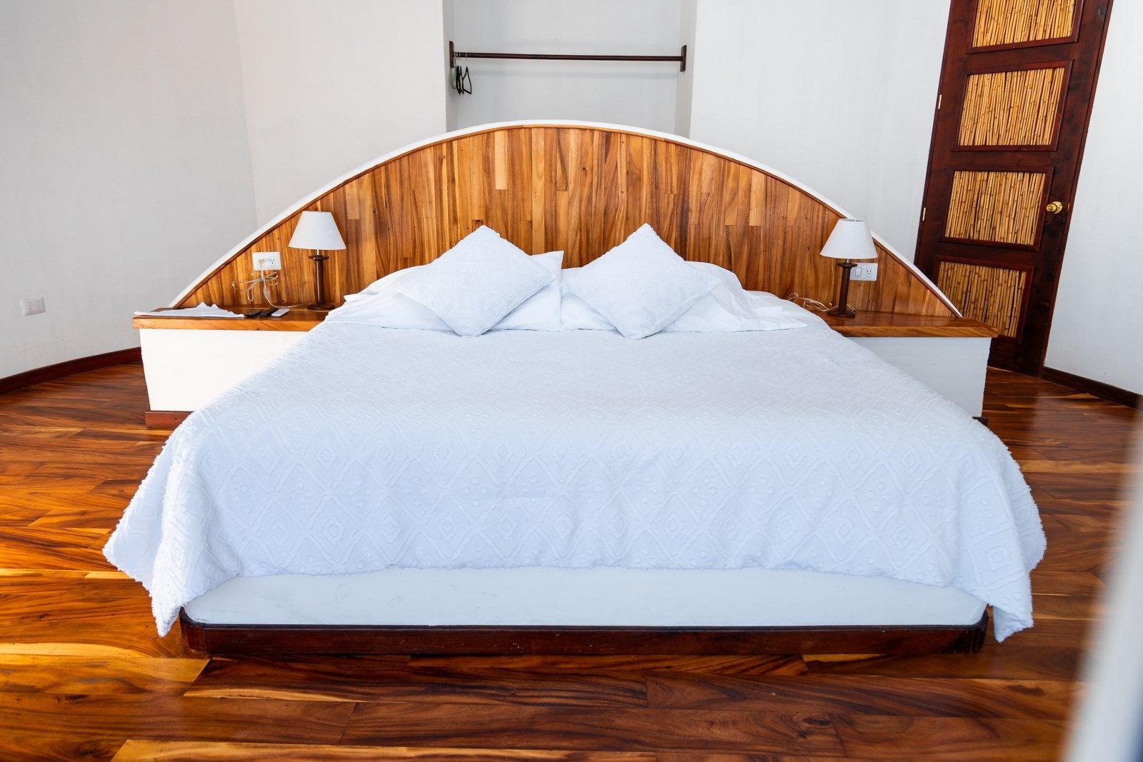 Un dormitorio con una cama grande y un cabecero de madera.