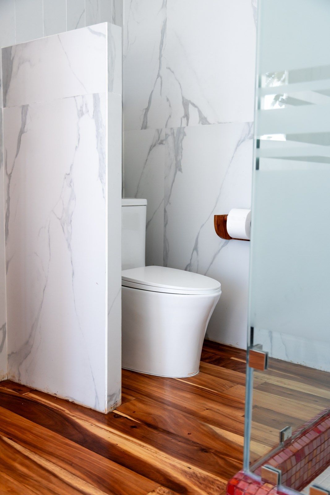 Un baño con inodoro y ducha a ras de suelo.