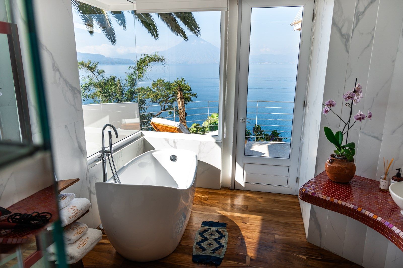 Un baño con bañera y vista al mar.