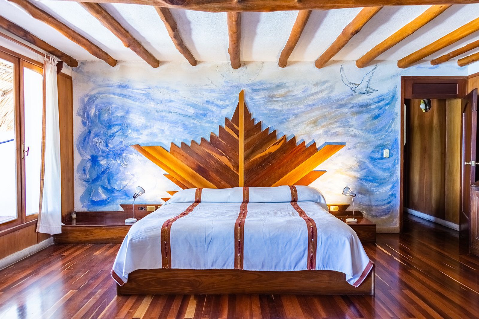 Un dormitorio con una cama y un cabecero de madera en forma de hoja de arce.