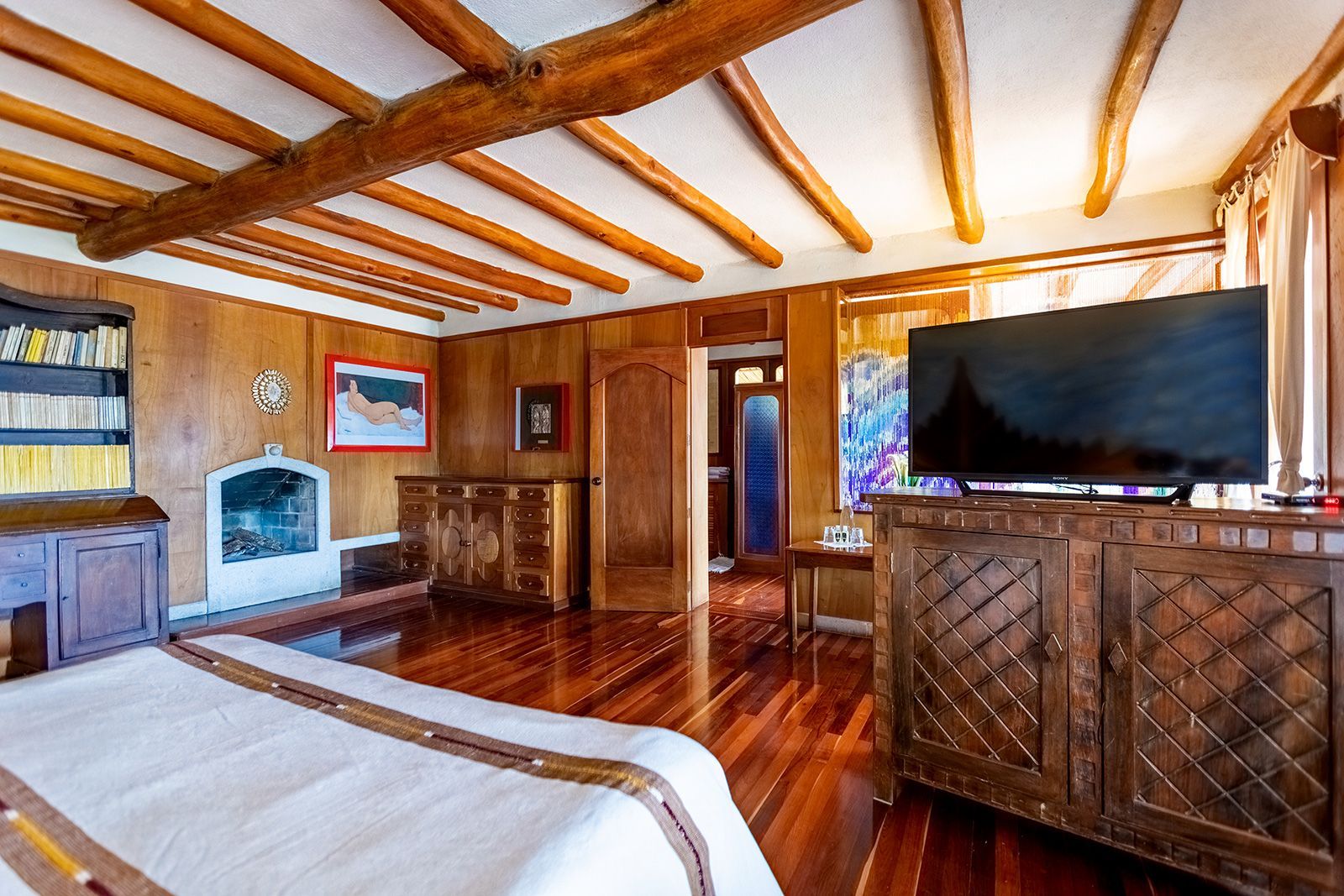 Un dormitorio con una cama grande y un televisor de pantalla plana.