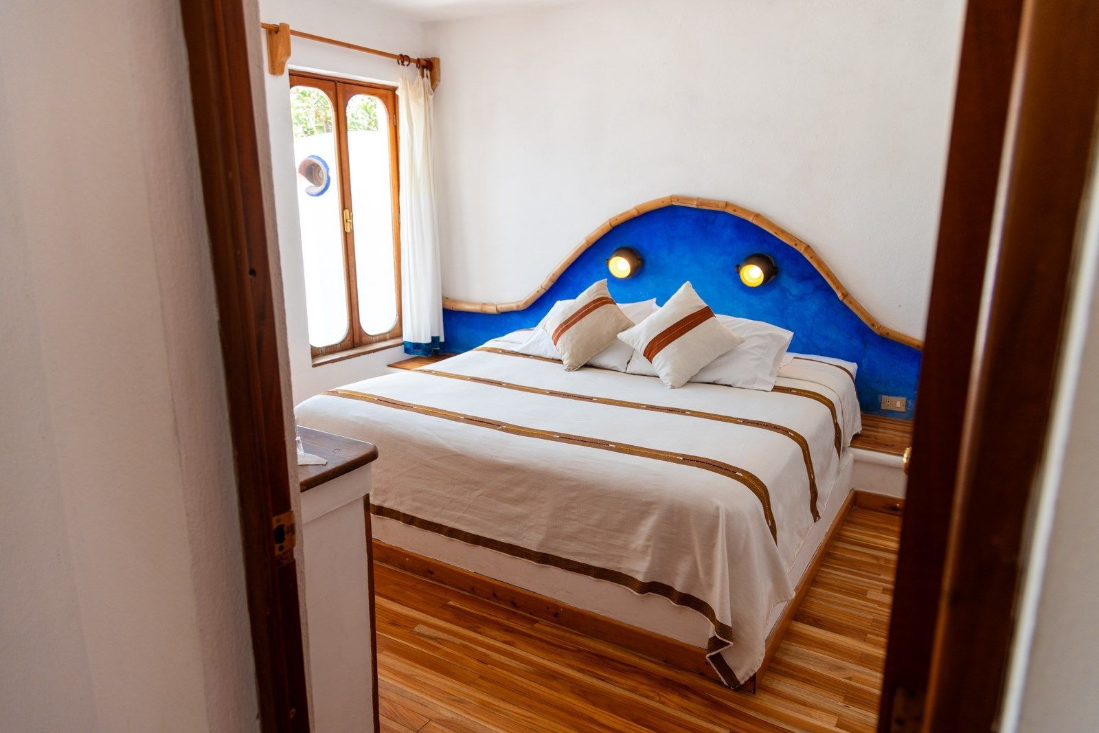 Un dormitorio con una cama grande y un cabecero azul. Tzampoc Resort