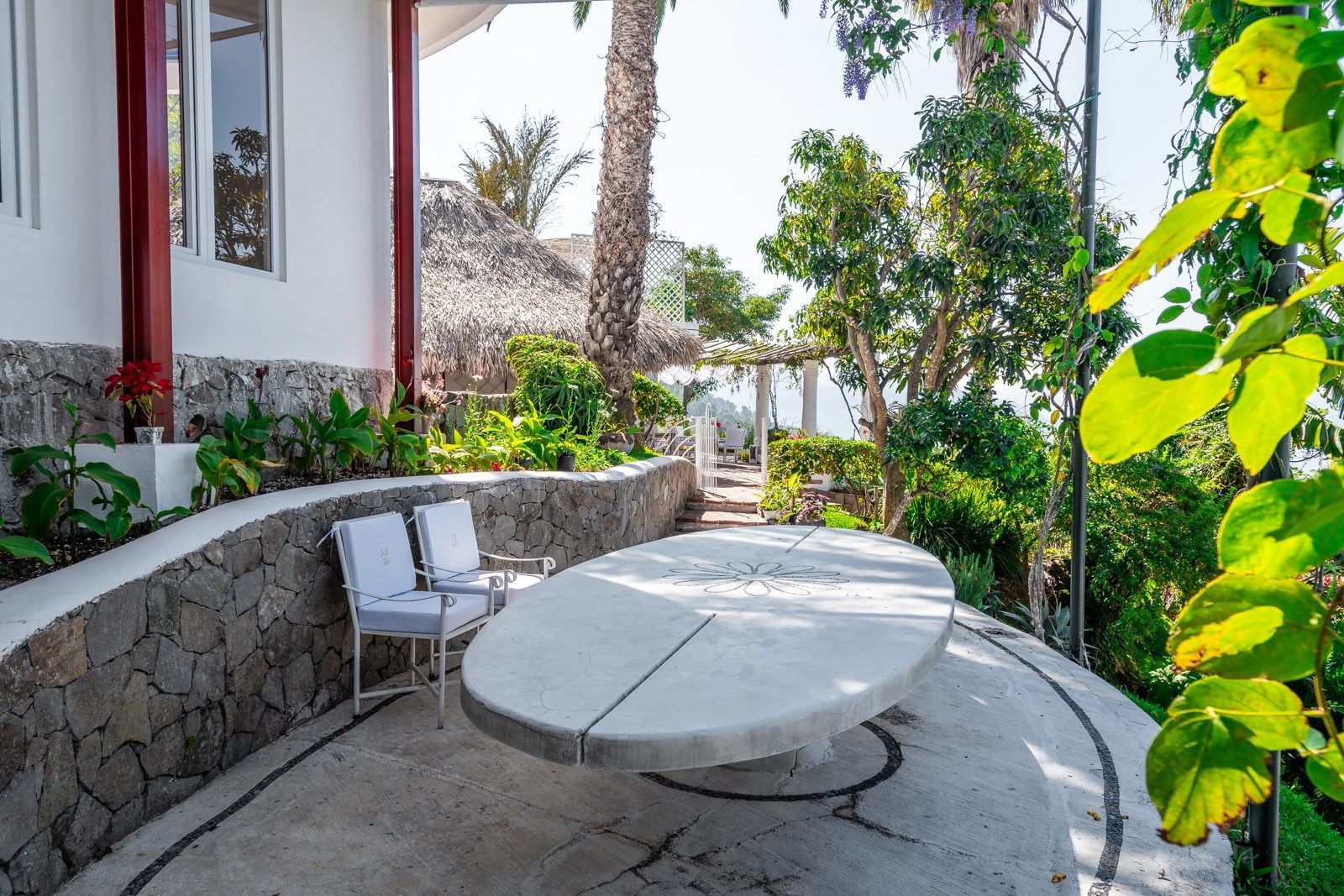 Un patio con una mesa redonda y sillas frente a una casa.