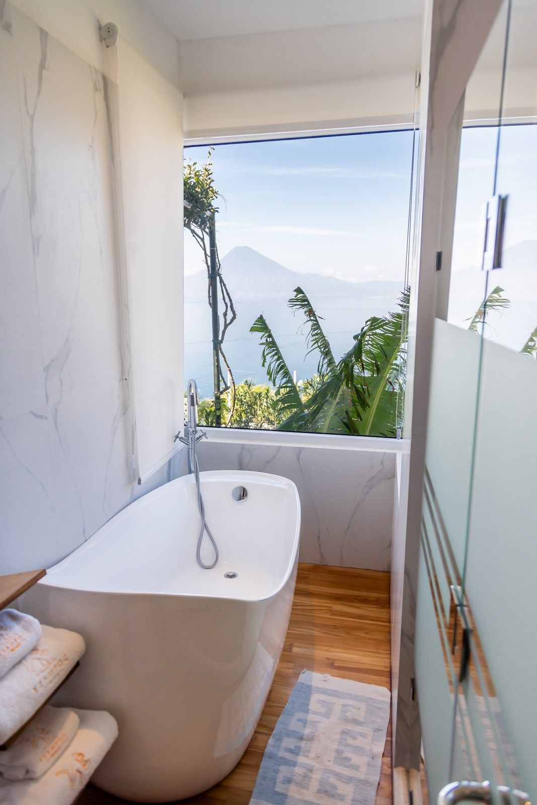 Un baño con bañera y una ventana con vista al mar.