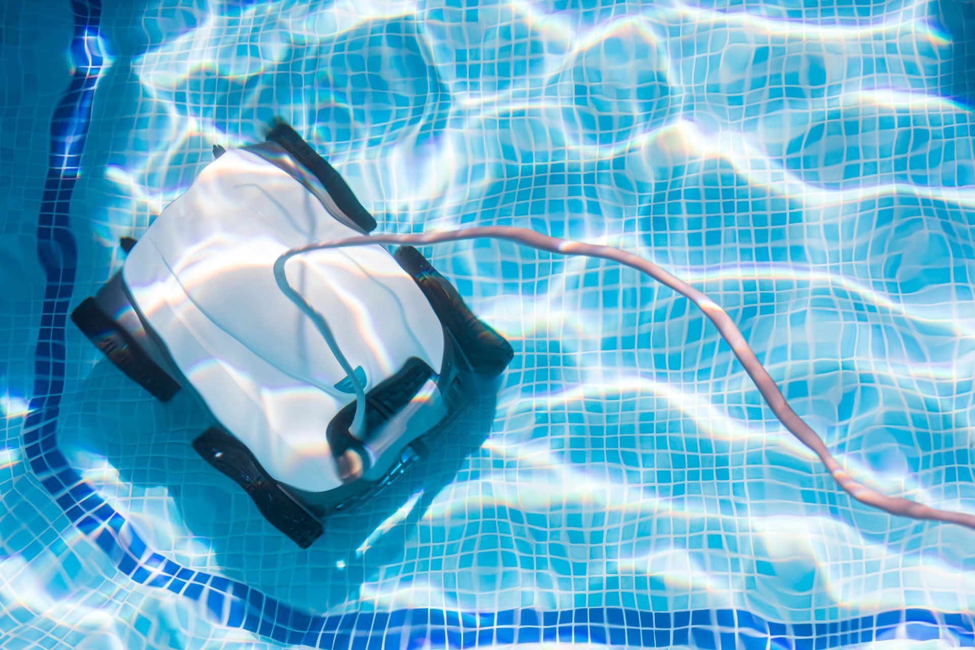 A robotic pool cleaner is floating on top of a swimming pool.