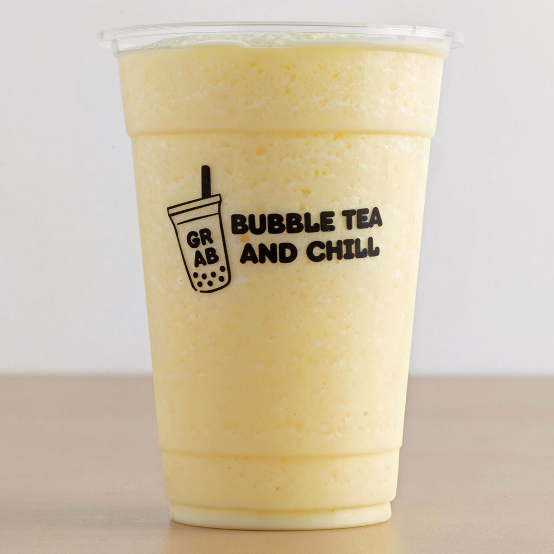 Yellow smoothie in a clear cup with