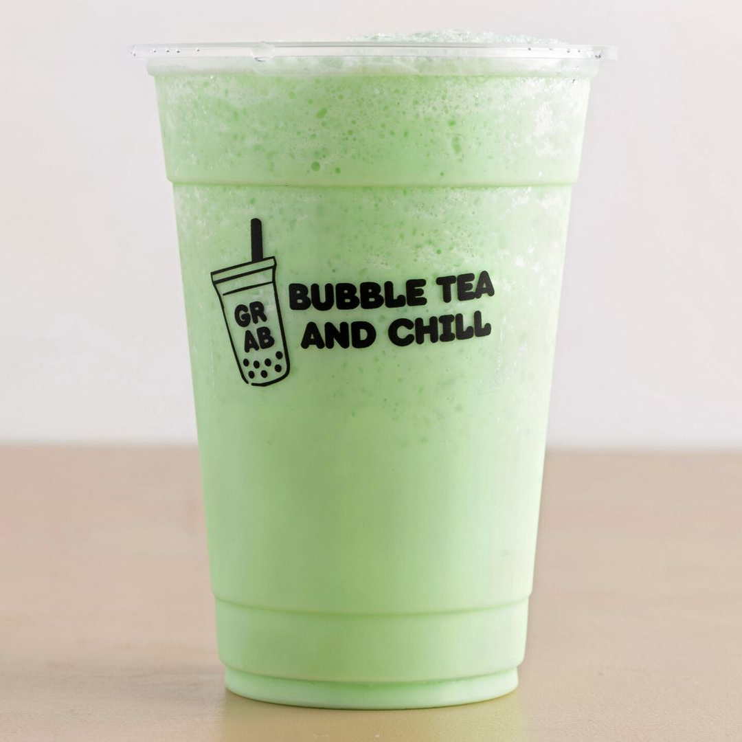 Green bubble tea in a clear plastic cup, logo reads