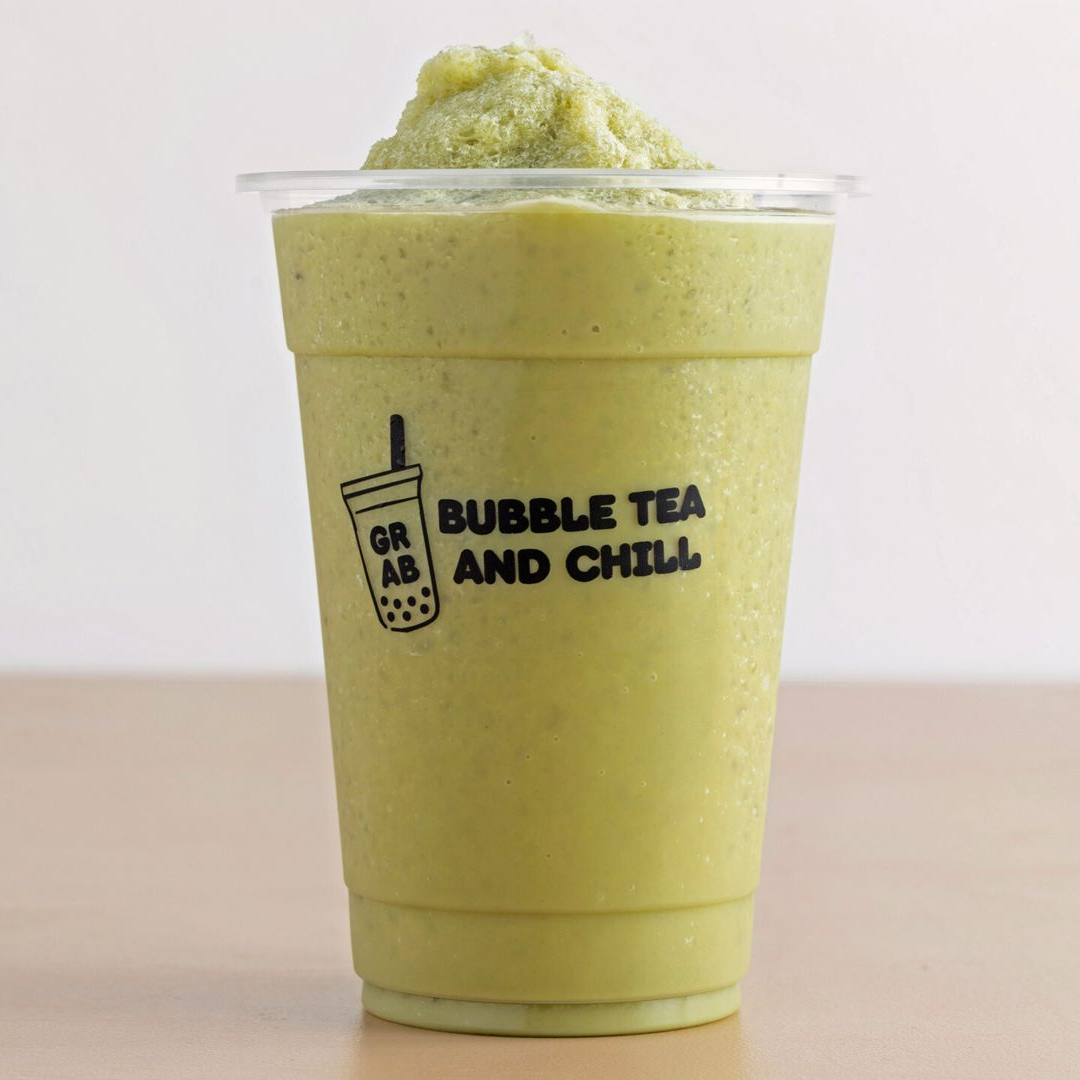 Green smoothie in a clear plastic cup with