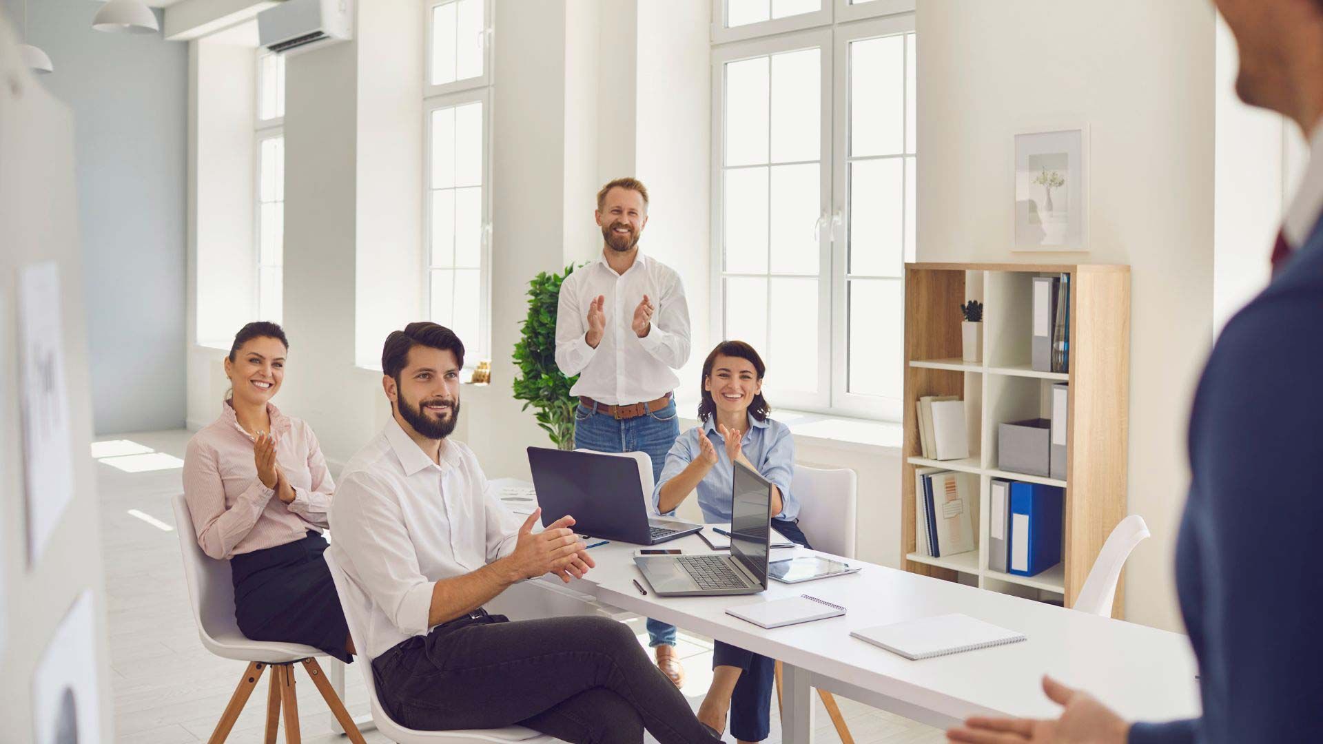 A man is giving a presentation to a group of people in an office.