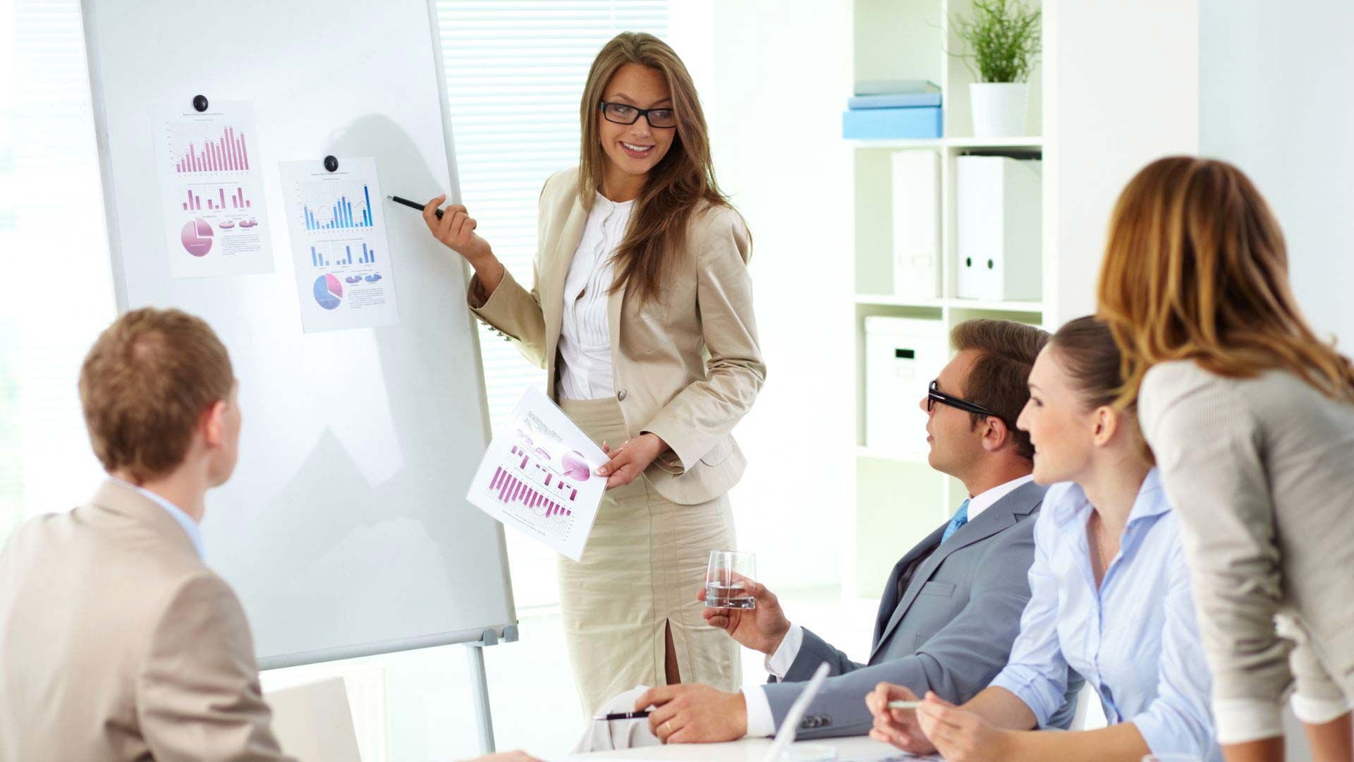 A woman is giving a presentation to a group of people.
