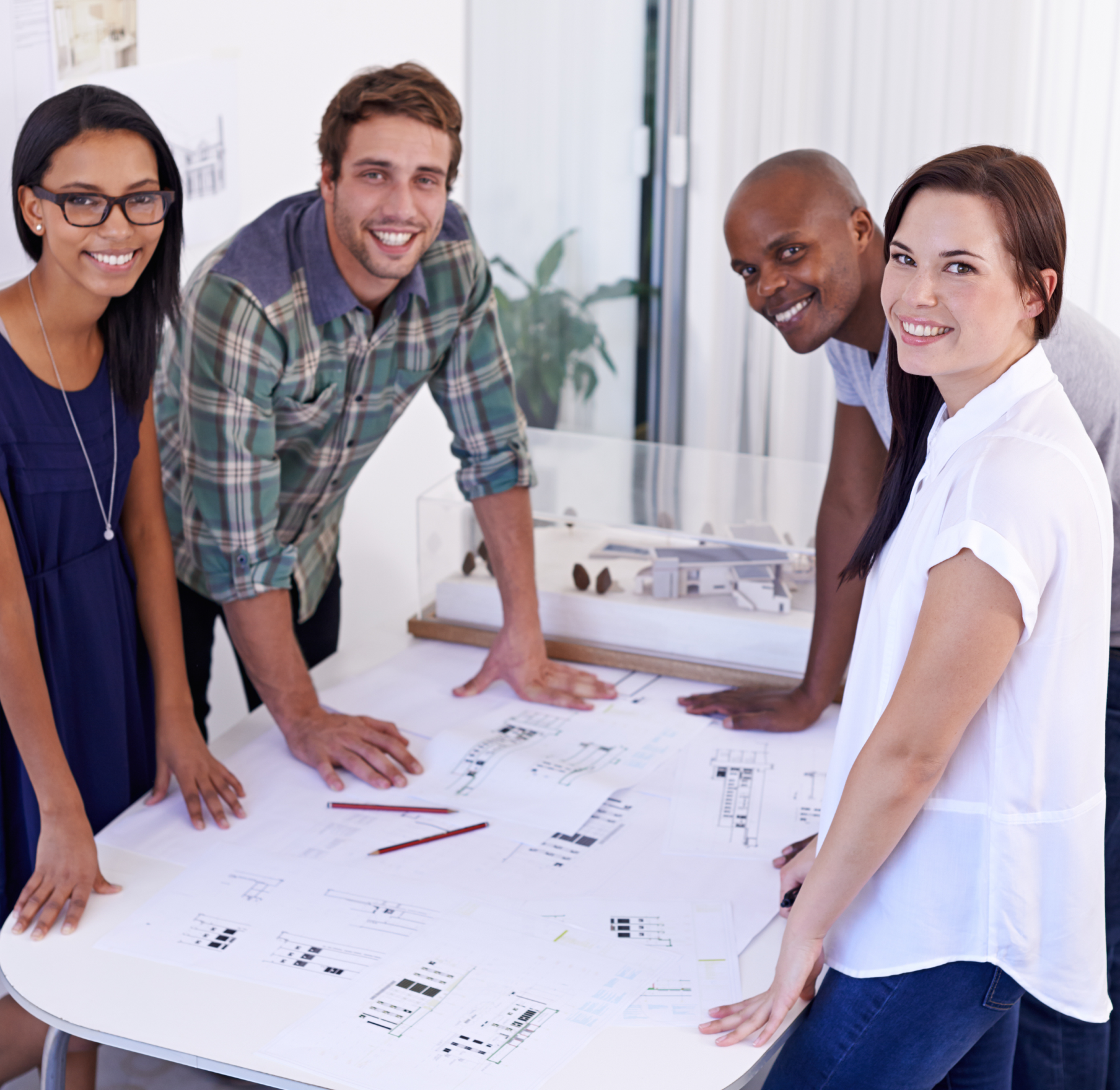 A group of people are sitting around a table with papers on it