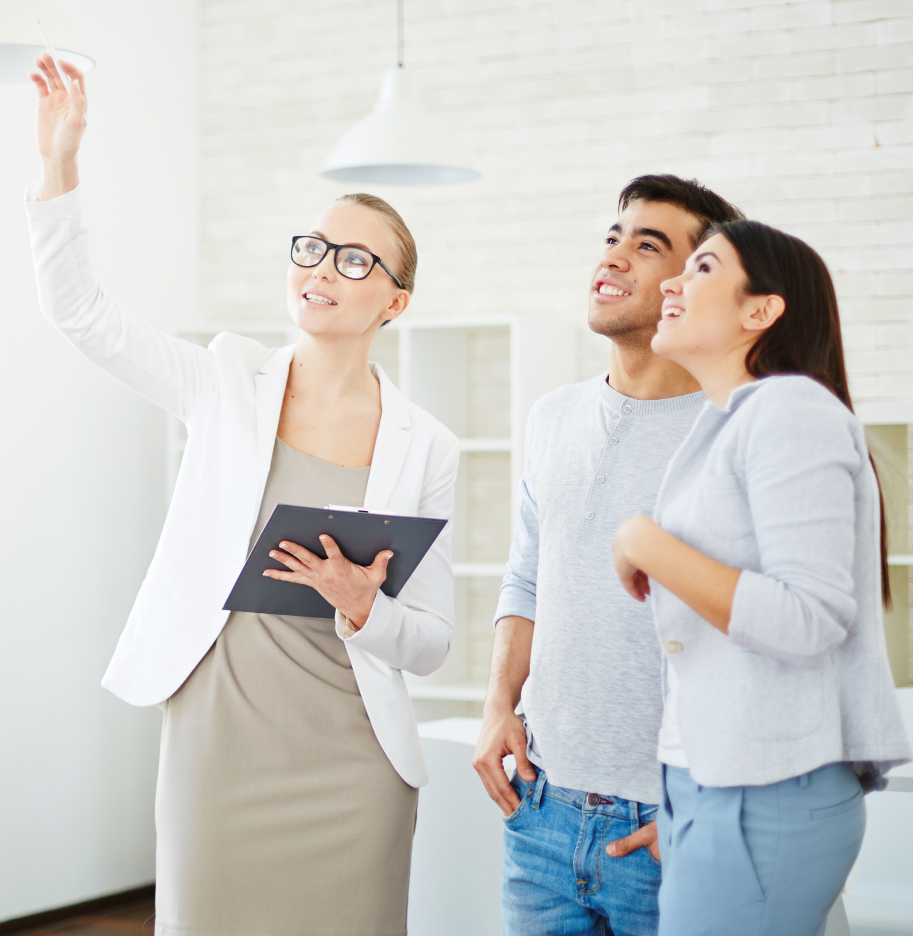 A man and two women are looking up at something while a woman holds a clipboard