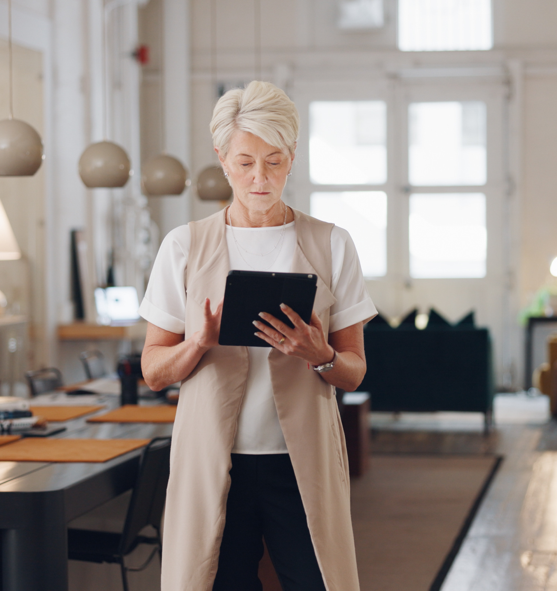 A woman is using a tablet in a living room