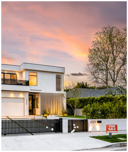 A large white house with a for sale sign in front of it