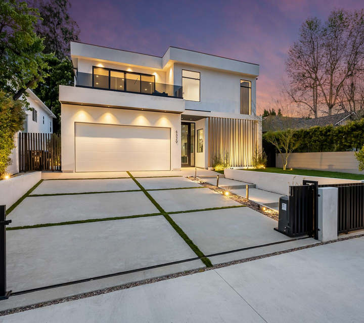 A large white house with a for sale sign in front of it