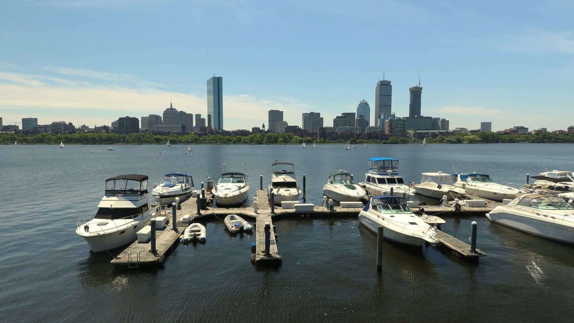 Yachts and boats in Boston Charles River with urban city skyline skyscrapers