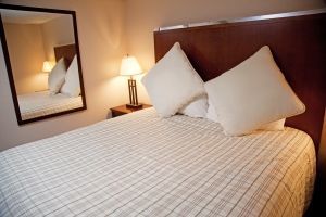 A hotel room with a bed and a mirror